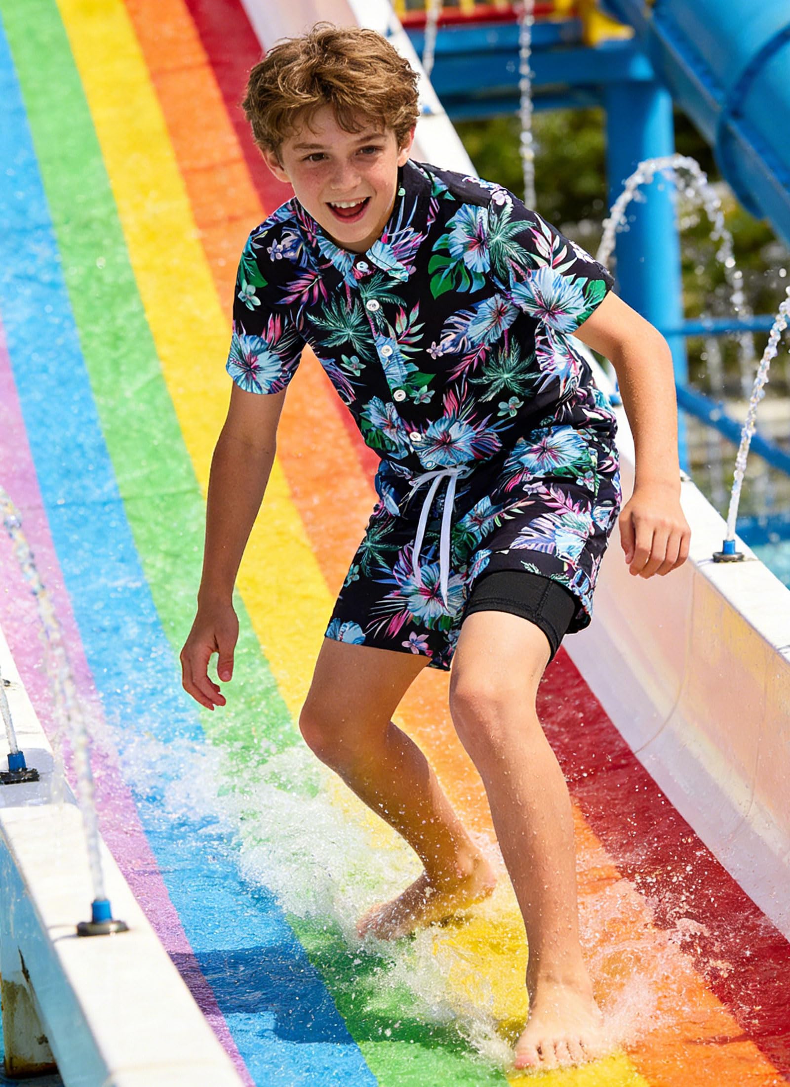 Boy wearing a tropical Hawaiian shirt and swim shorts set during outdoor activities, comfortable summer outfit for kids vacations.