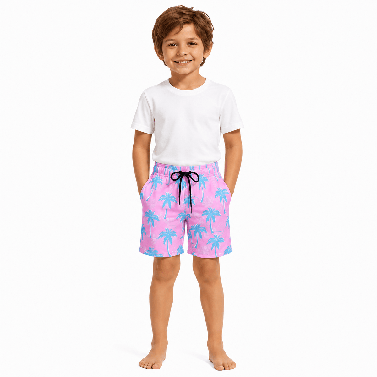 Young boy wearing pink maple leaf swim shorts designed for matching family beach outfits and summer swimming.