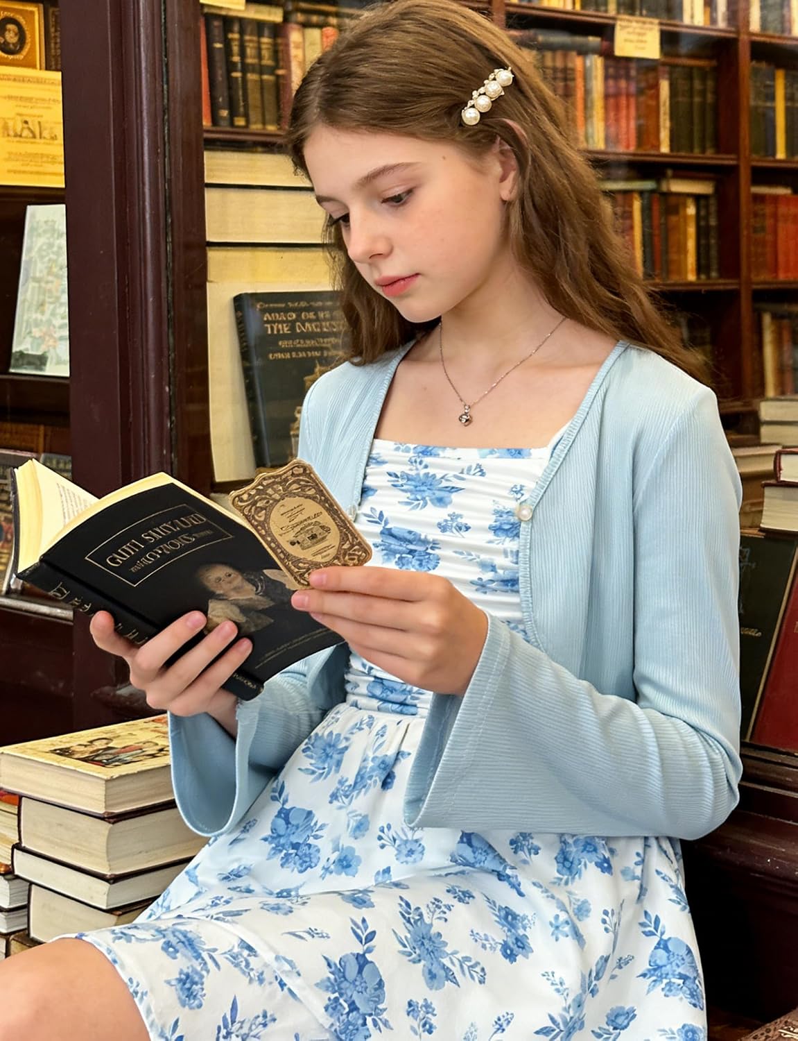 Girl wearing the Blue Floral cardigan dress set while reading indoors in a casual everyday setting.
