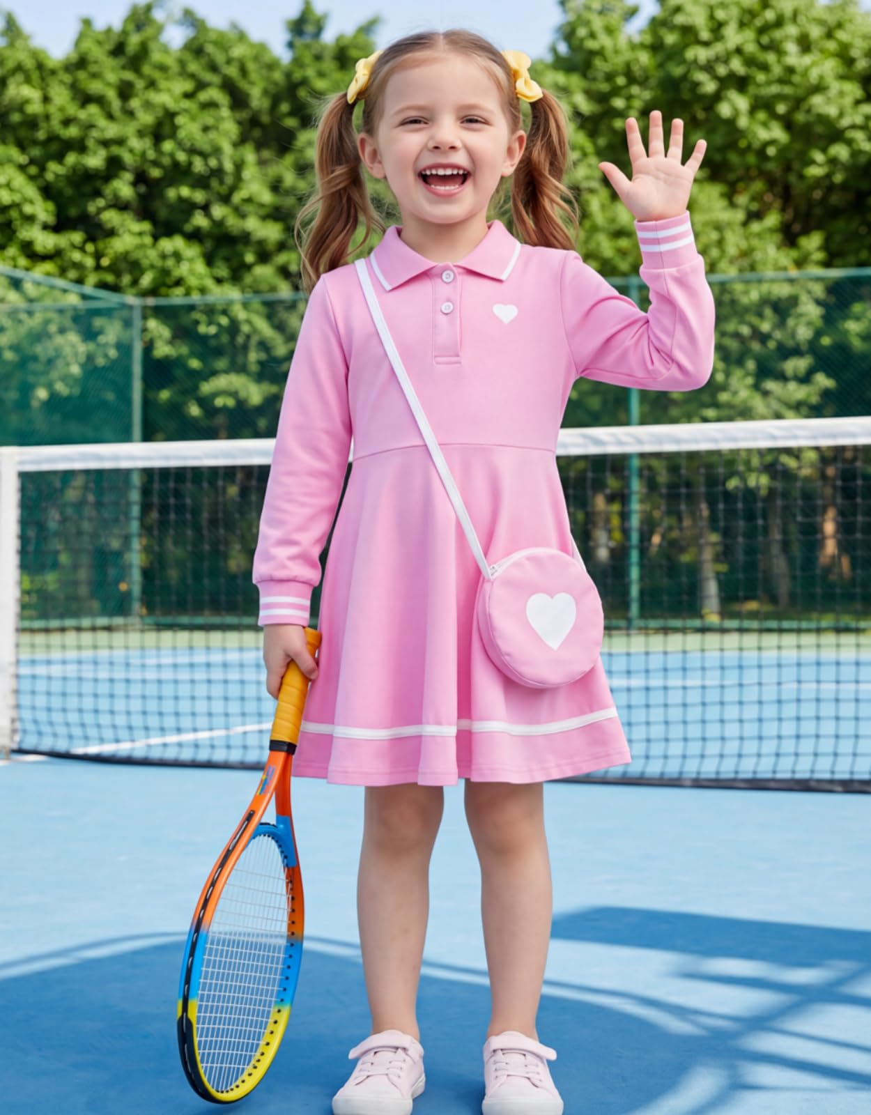 Girl wearing a pink long sleeve polo dress on a tennis court, showing a sporty preppy style with a comfortable A-line dress design.