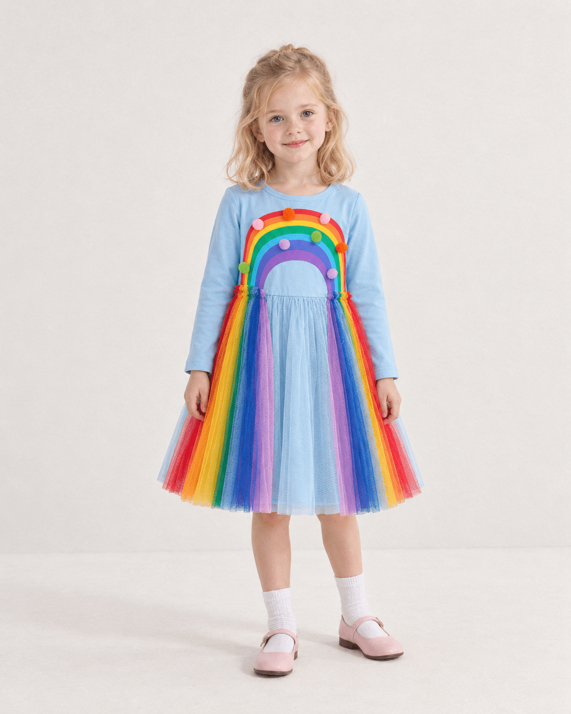 Girl wearing a rainbow tulle dress in a front standing pose, showing the colorful layered skirt and princess-inspired style.