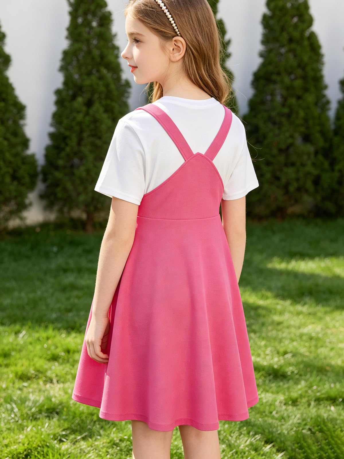 Back view of girls waffle overall dress with adjustable shoulder straps and layered T shirt styling, comfortable kids outfit design.