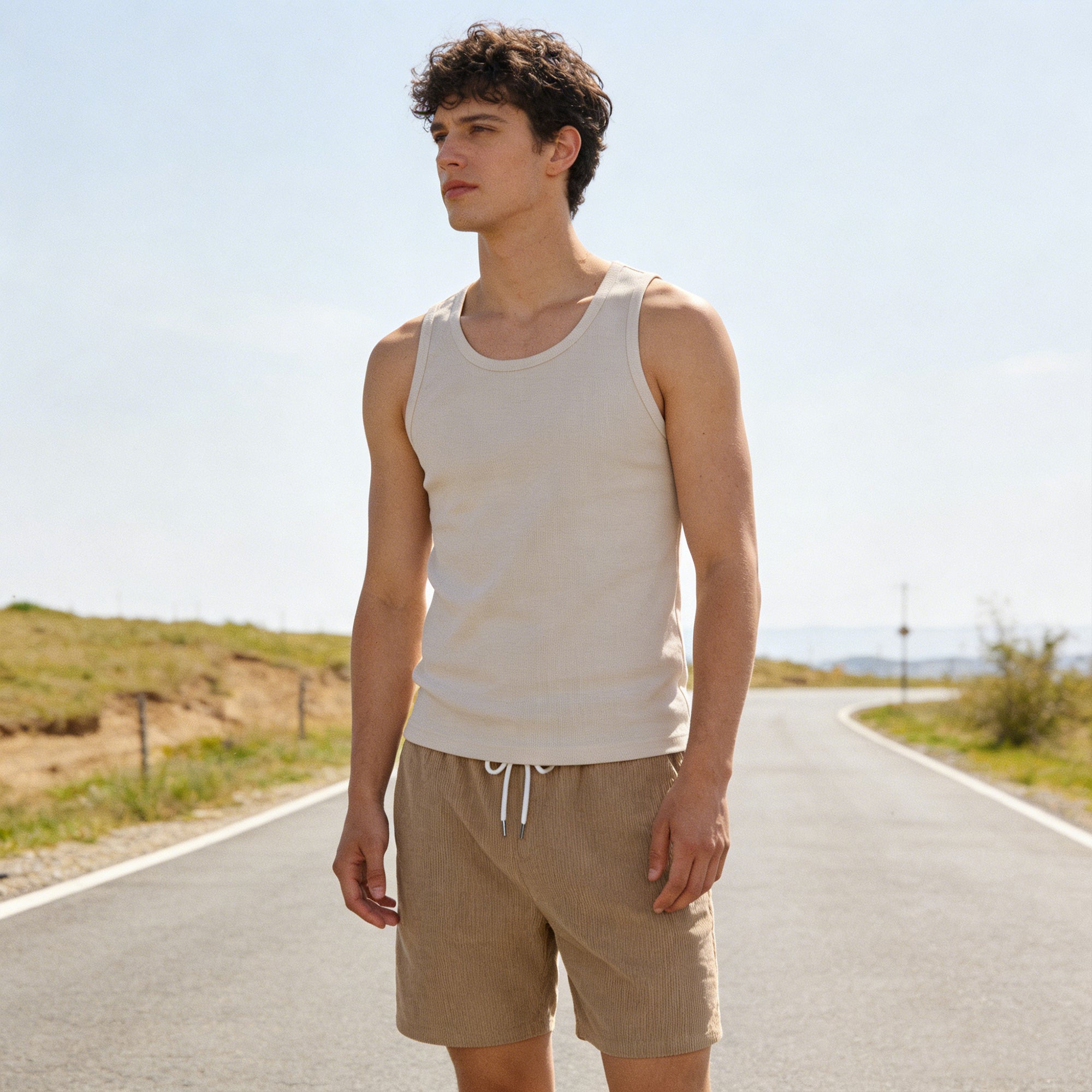 Man wearing linen blend drawstring shorts with a casual summer tank top, lightweight vacation outfit for outdoor activities and warm weather.