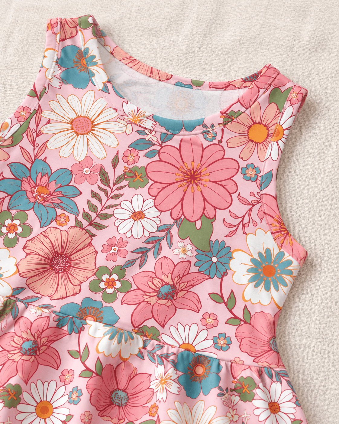 Close-up of the girls Pink Daisy Floral dress showing the sleeveless neckline and colorful pink, blue and green flower print.