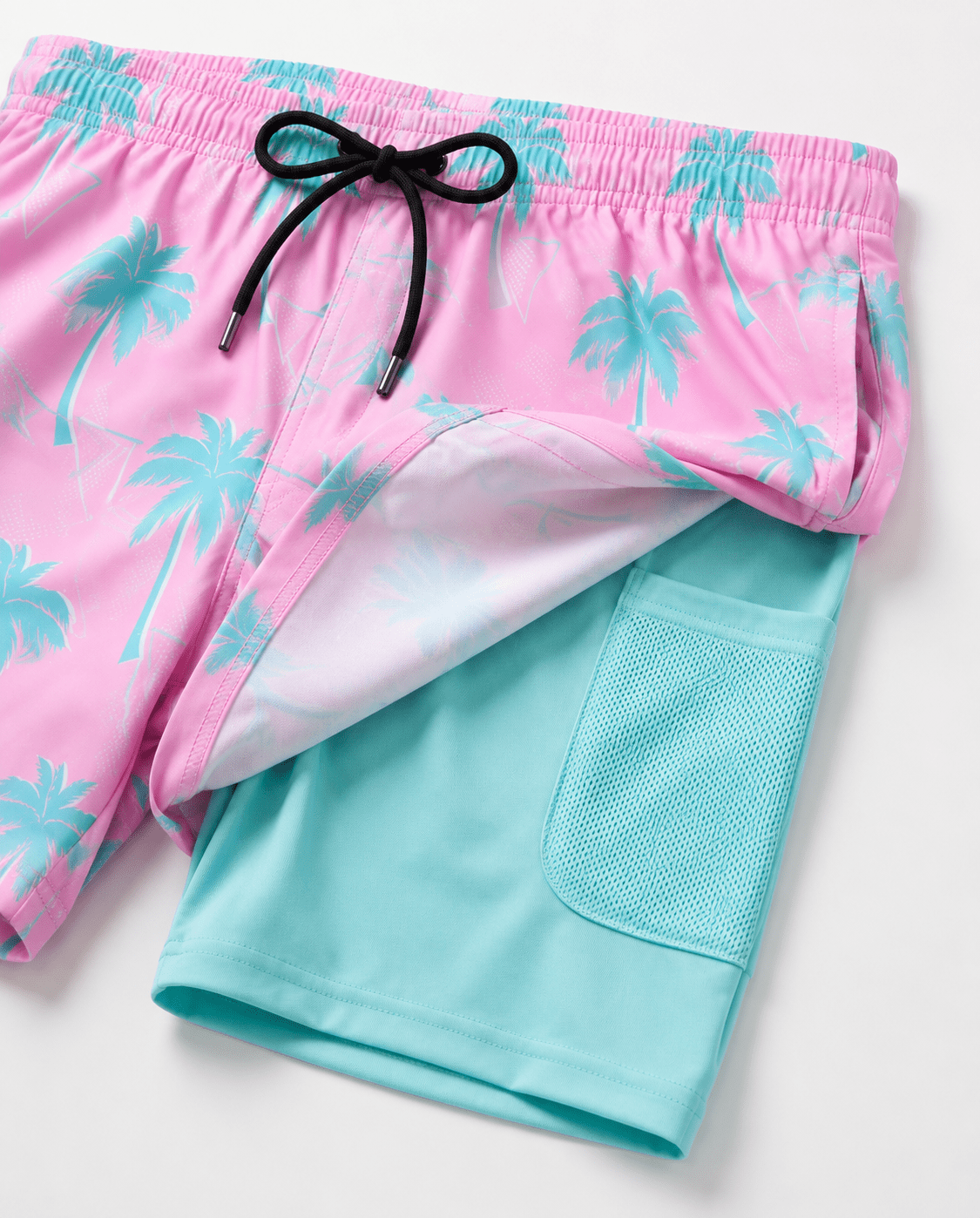 Close up of pink maple leaf printed swim trunks showing colorful pattern and lightweight quick dry fabric.