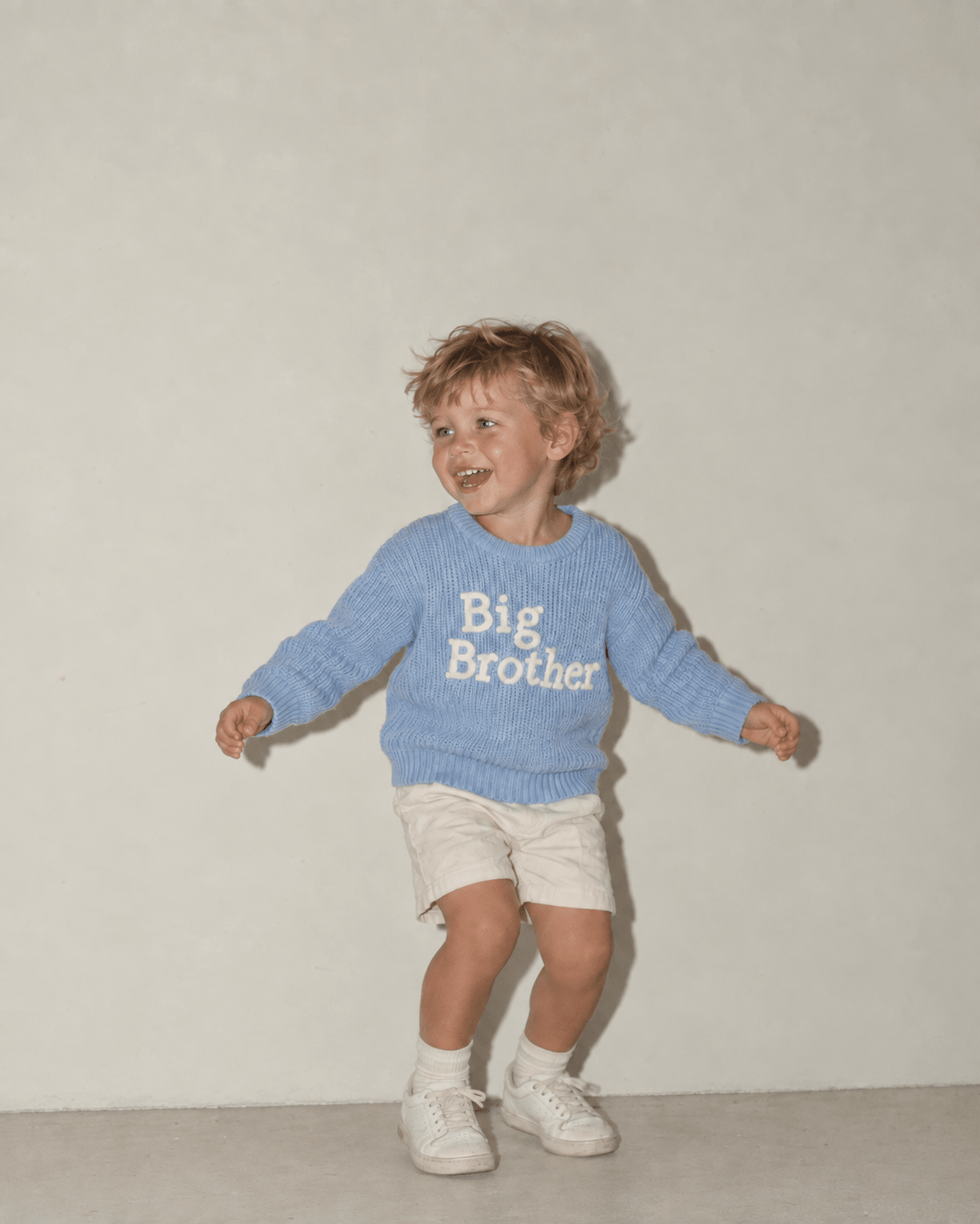 Toddler boy wearing a Big Brother graphic sweater while playing, showing the comfortable fit and soft long sleeve design.