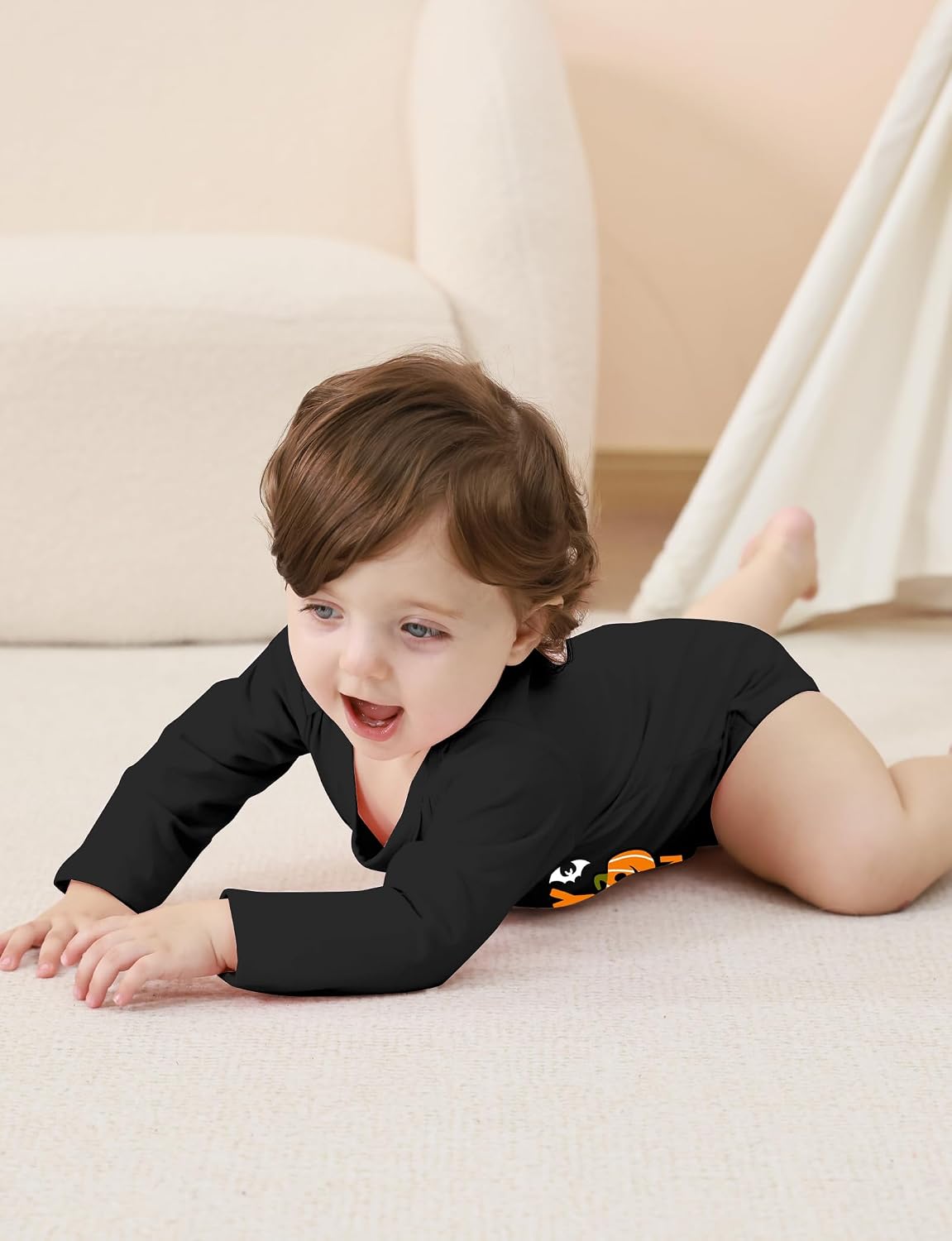 Toddler wearing a black Halloween graphic bodysuit during indoor play, showing the flexible long sleeve design for comfortable movement.