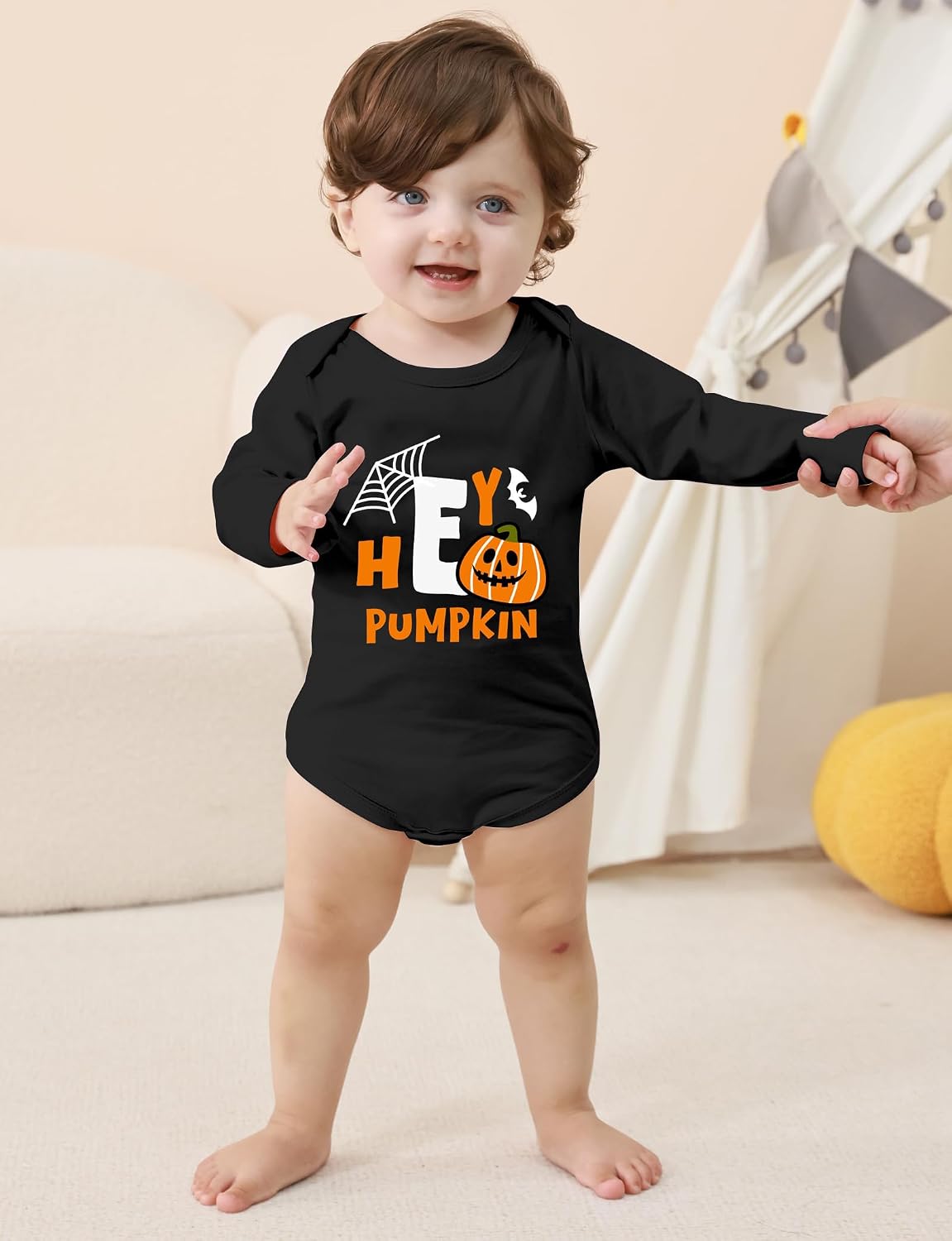 Toddler standing indoors in a black Halloween long sleeve bodysuit, showing the full front fit and comfortable stretch design.