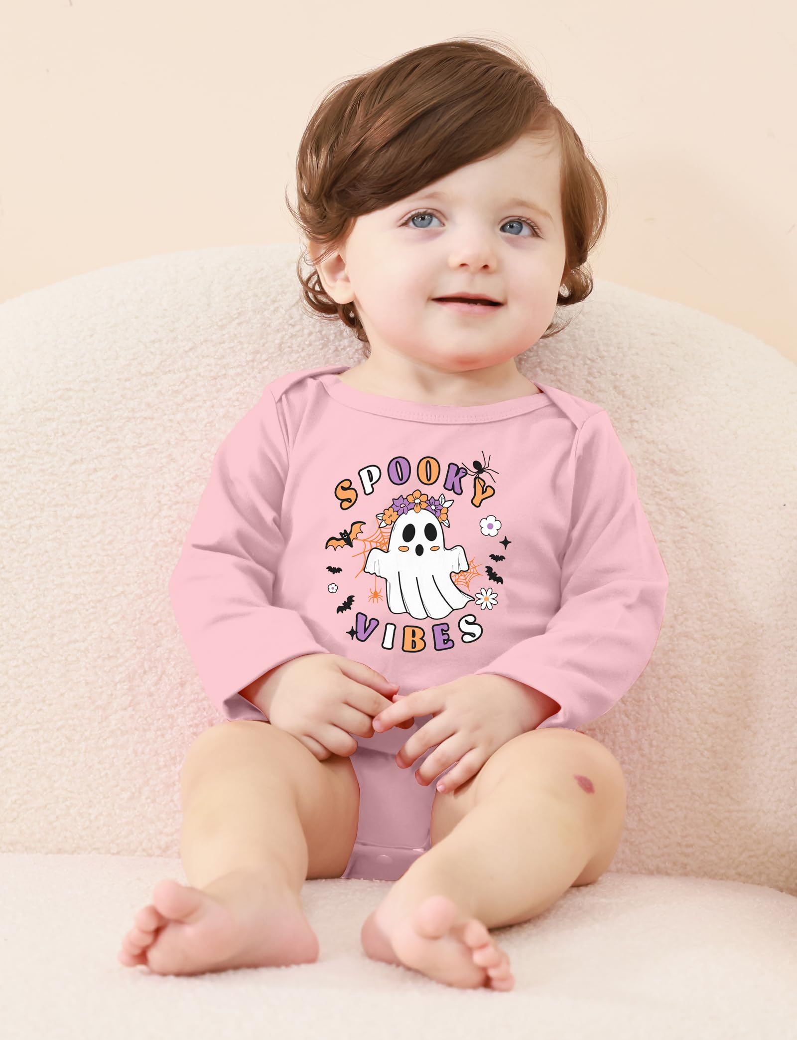 Toddler wearing a pink Halloween ghost graphic long sleeve bodysuit indoors, showing the comfortable fit for parties, photos and fall wear.