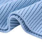 Close-up of baby blue toddler sweater fabric showing the soft cotton acrylic blend texture and knit construction.