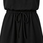 Close-up of the black girls swing dress showing the gathered waist detail and flowing A-line skirt construction.