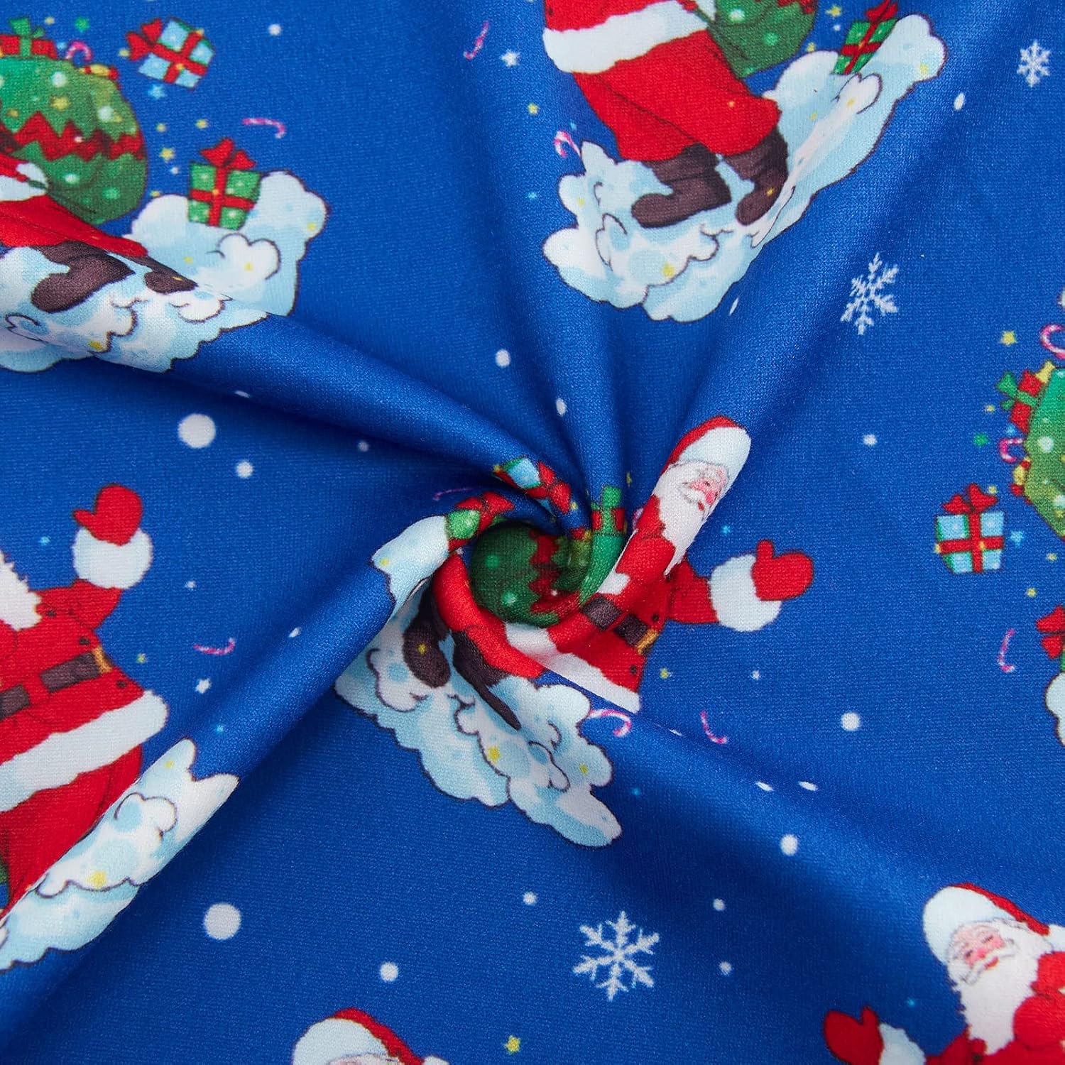 Close-up of blue kids pajama pants showing the Santa Claus and snowflake print, soft fabric texture and colorful holiday pattern.