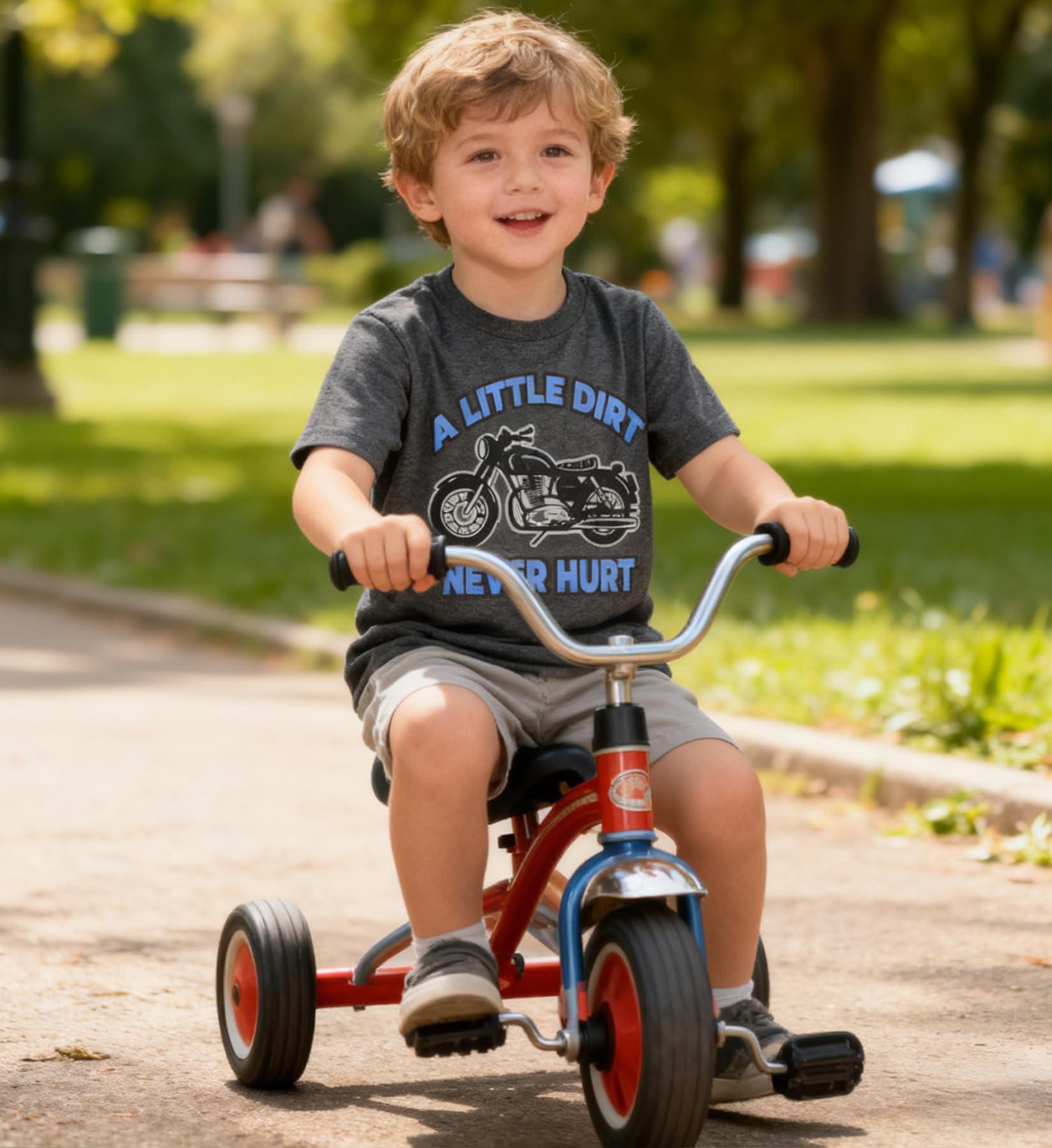 Happy boy riding a bicycle wearing a gray graphic T shirt, casual kids clothing for summer outdoor play