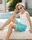 Boy wearing banana swim shorts outdoors, showing a comfortable summer look for swimming and leisure activities.
