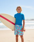 boy wearing tropical swim trunks at the beach during summer vacation