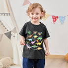 Boy wearing a black dinosaur graphic T shirt indoors, showing a comfortable casual kids outfit for everyday activities.