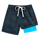 Boys black teal leaf printed swim trunks with quick dry fabric and comfortable compression liner.