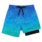 Boys blue gradient swim trunks with tonal palm tree print, black compression liner and adjustable drawstring waist for beach and pool wear.