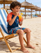 Side view of boys Hawaiian print swimsuit set showing comfortable fit and matching swim shorts for active kids.