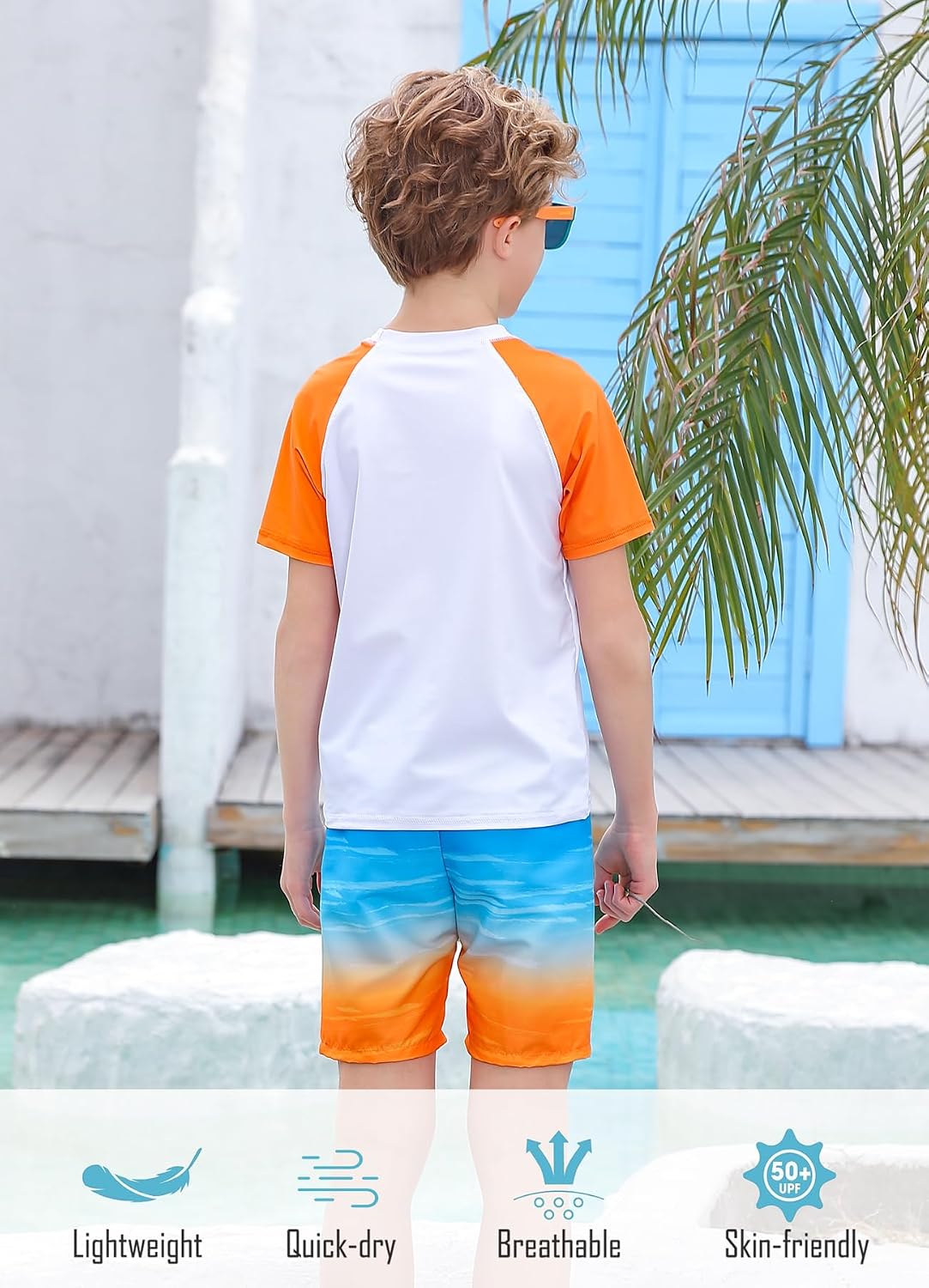 Back view of a boy wearing an Orange Hawaii rash guard swim set, showing the short sleeve top and gradient swim trunks.