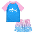 Boys Pink Shark two-piece swim set with blue and pink short sleeve rash guard and coordinating shark print swim trunks.