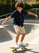 Boy skateboarding in a breathable striped polo shirt designed for active everyday adventures.