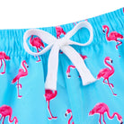 Close up of boys blue flamingo swim trunks showing the adjustable drawstring waistband and elastic waist design for a secure fit.