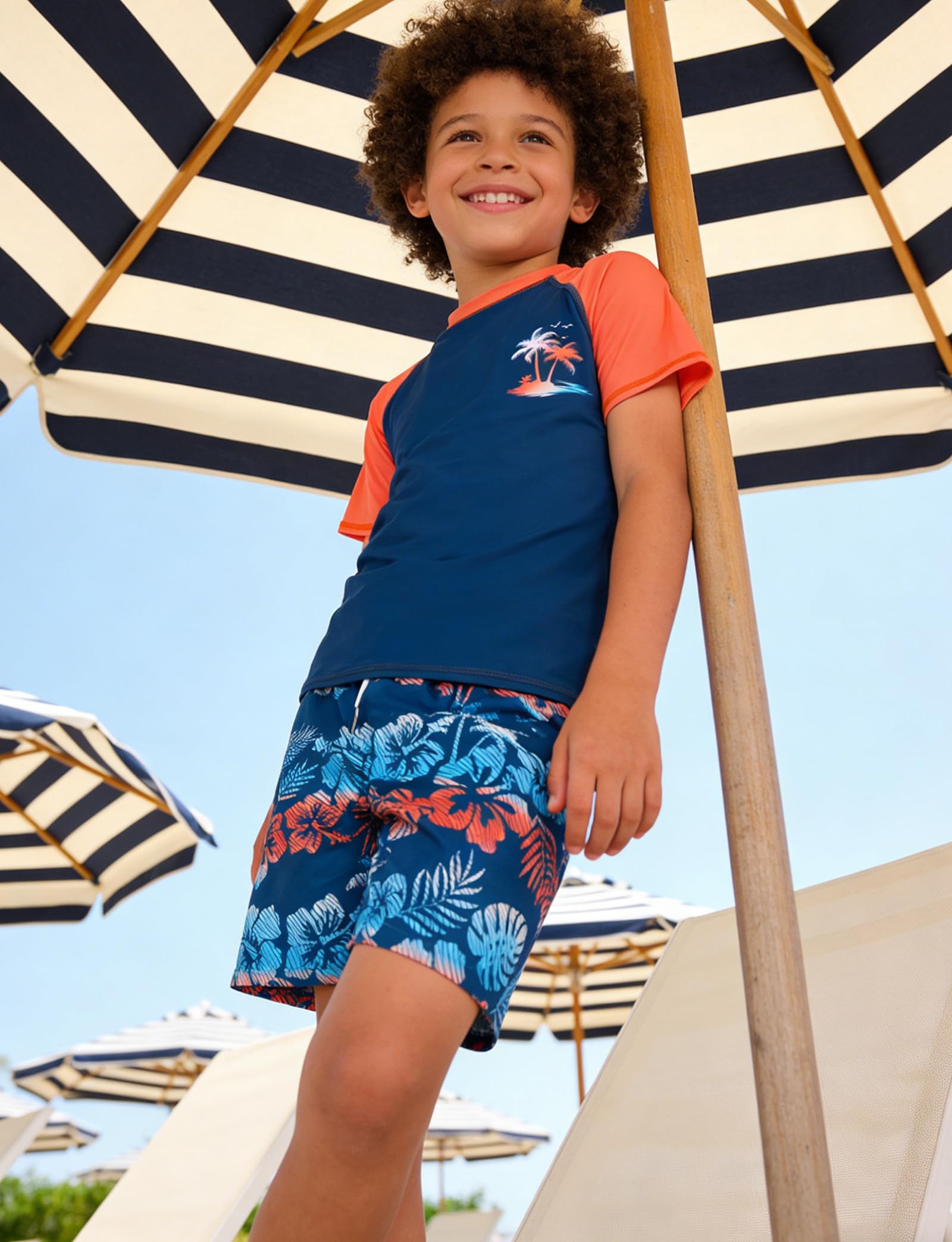 Boys tropical print swim set with short sleeve top and swim shorts styled for beach holidays and outdoor activities.