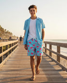 boy wearing tropical swim shorts walking near the beach resort