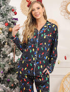 Woman wearing black Christmas lights pajama set with colorful holiday pattern for cozy winter evenings