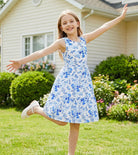 Girl wearing a blue floral rainbow strap sundress outdoors, showing the comfortable fit and playful summer style.