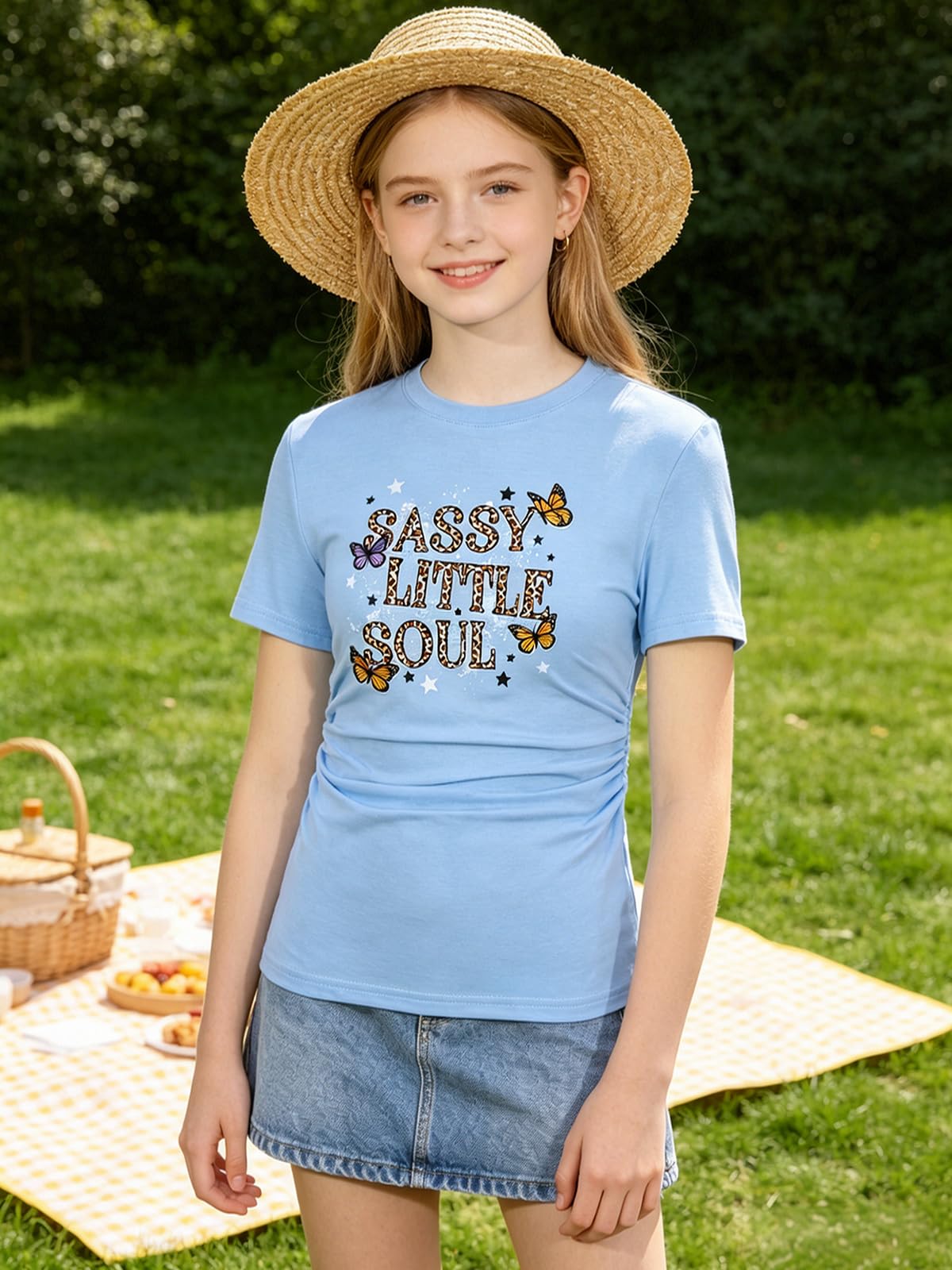 Girl wearing a blue graphic T shirt outdoors, showing a casual everyday outfit style with a comfortable ruched side design.