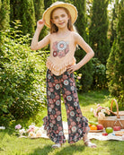 Girl wearing a floral ruffle top and pants outfit outdoors, comfortable summer clothing for kids.