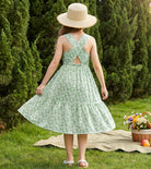 Girl wearing a rainbow strap sundress outdoors with a summer hat, cute kids dress for vacations and garden activities.