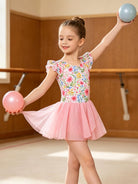 Young girl wearing a sparkle ballet leotard dress with flutter sleeves and sequin skirt while practicing dance movements.