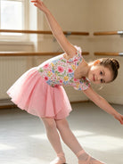 Girl spinning in a ballet dance dress with layered sequin skirt, showing the comfortable fit and elegant movement of kids dancewear.