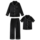 Girls black collared pajama set featuring a long sleeve button front top and matching pants with a classic sleepwear design.