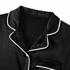 Close-up of the black girls pajama set showing the soft fabric texture, collar design and contrast trim details.