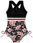 Girls black printed one piece swimsuit with cross back design and UPF 50+ fabric for pool, beach and vacation wear.