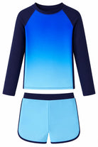 Girls blue gradient long sleeve rash guard swimsuit set with matching swim bottoms, quick dry fabric and flexible fit for swimming and beach wear.