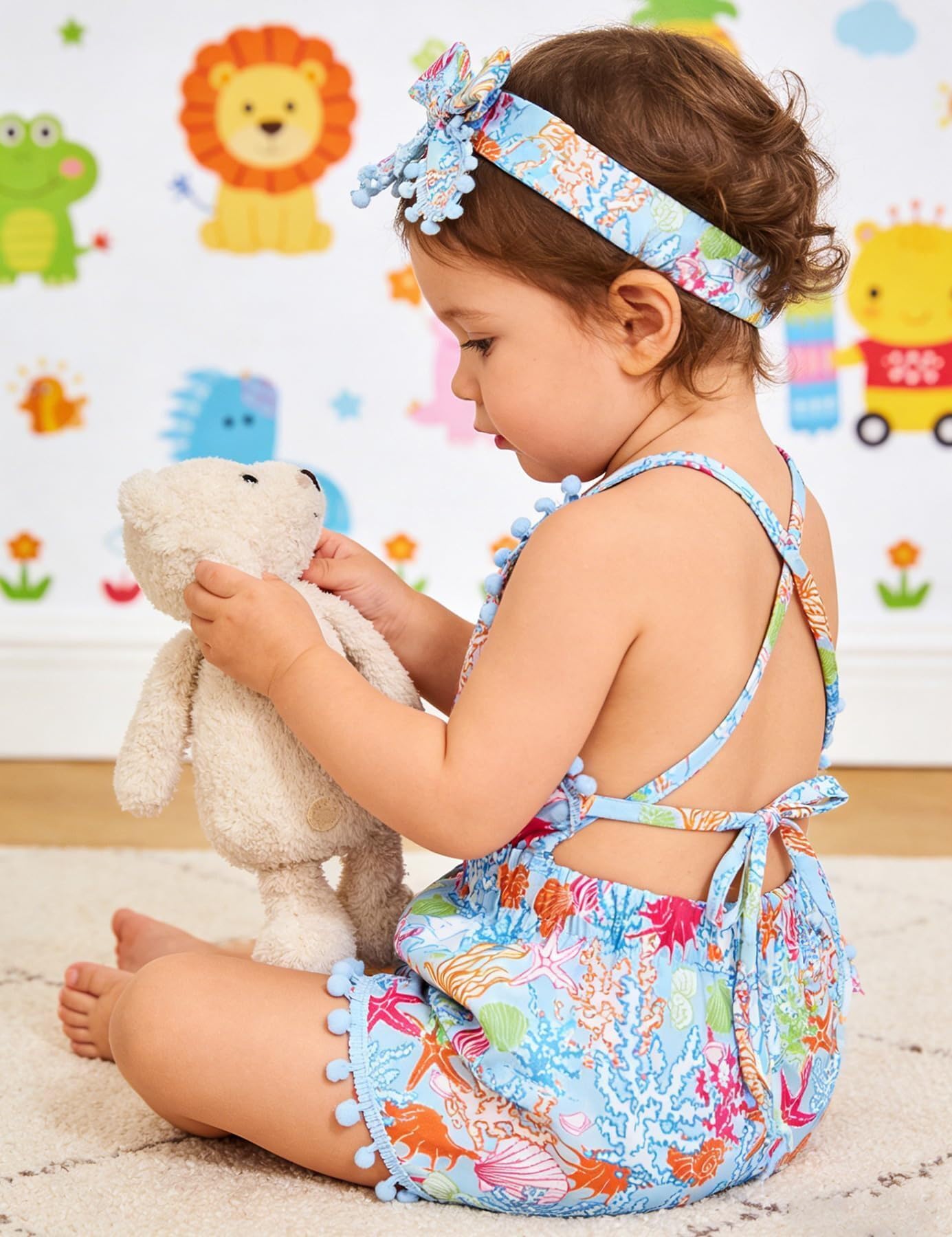 Young girl wearing a cute cotton blend romper dress with matching headband, perfect toddler outfit for playtime and summer activities.