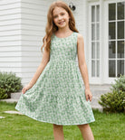 Girl wearing a cross strap sundress showing the colorful shoulder strap design and flowing skirt silhouette.