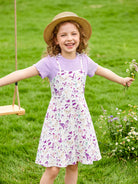 Girl wearing a floral sundress outfit outdoors, comfortable lightweight clothing for summer play and family occasions.