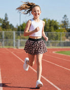 Girl wearing leopard sports shorts during outdoor activities, showing flexible fit and comfortable movement for active kids.