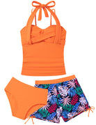 Girls orange tankini swimsuit featuring tropical leaf print design