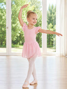 Girl wearing a pink ballet leotard dress while performing a ballet pose, showing the elegant skirt shape and flexible dance outfit for practice and performances.