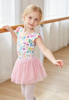 Girl wearing a pink floral ballet leotard dress with skirt while practicing at a ballet barre, comfortable dance outfit for ballet classes and performances.