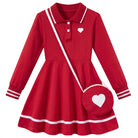 Girls red long sleeve polo dress with white contrast trim and matching heart shoulder bag, featuring a classic collar and flared skirt.
