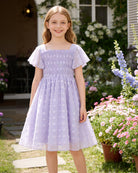 Girl wearing a ruffle sleeve Swiss dot dress outdoors, perfect kids occasion wear for birthdays, parties and family photos.