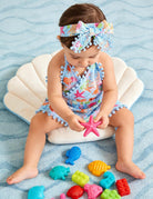 Little girl wearing a printed romper dress while playing, showing a comfortable lightweight design for daily wear and vacations.